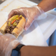 hands preparing an italian beef sandwich